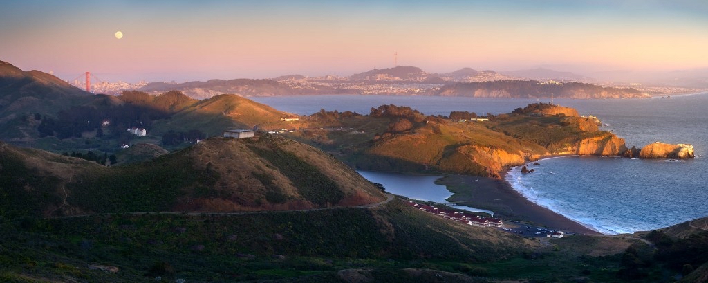 San Francisco Bay Area skyline at dusk with commercial towers and the bay in the foreground.