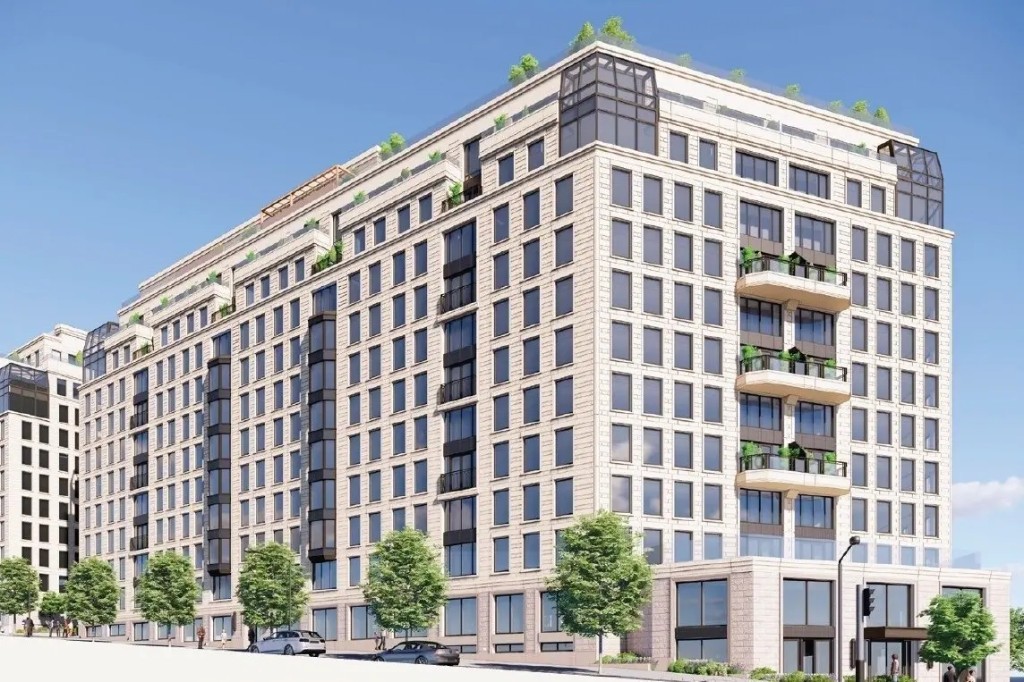 Modern multi-story building with terraces and street trees under a clear sky.