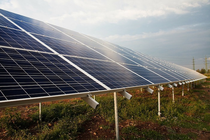 Ground-mounted solar panel array in a field.