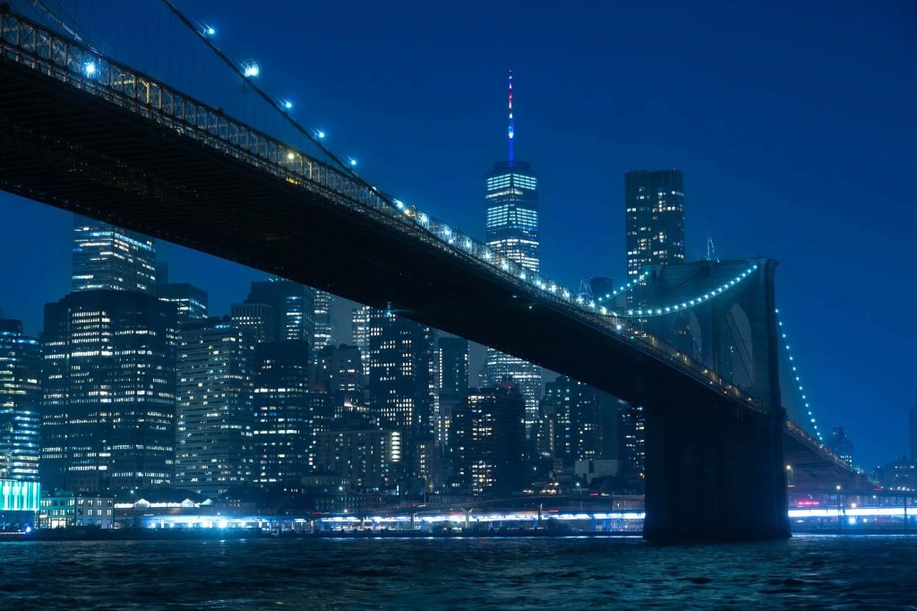New York City skyline at night with illuminated towers.